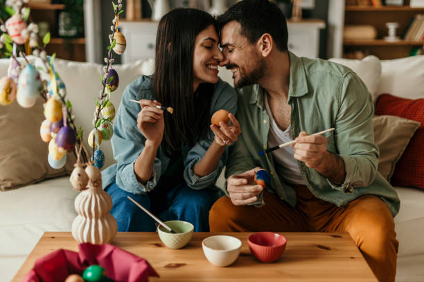 istock Couple painting easter eggs at home, enjoying their time together 2206270464