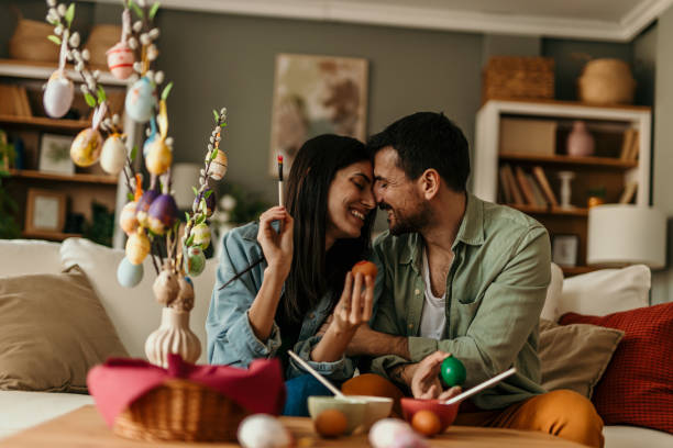 istock Couple painting easter eggs, showing love and affection at home 2206270504