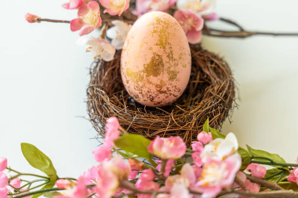 istock Golden Easter Egg in Nest with Pink Flowers 2206270585