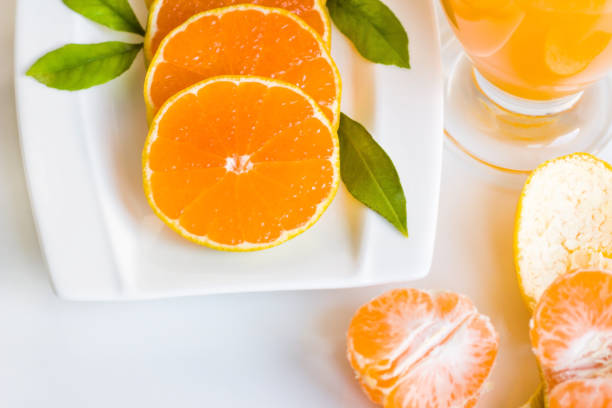 istock Sliced tangerine with fresh green leaves 2206270881