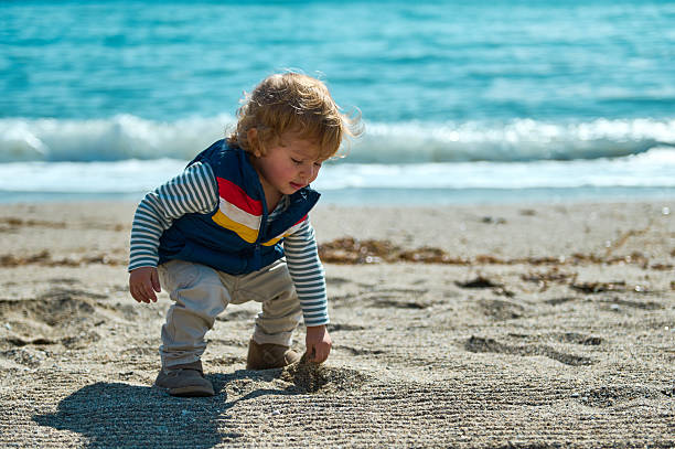 istock Young Child Playing on a Sandy Beach on a Sunny Summer Day 2206270992
