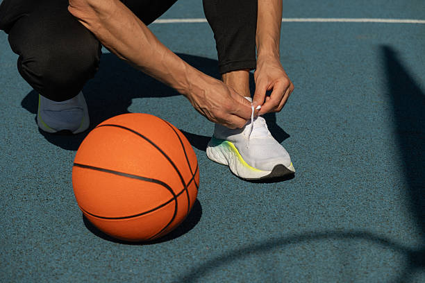 Two basketball sneakers with white soles. Close-up. Sneakers are standing on a wooden stand. A map of the world in the background