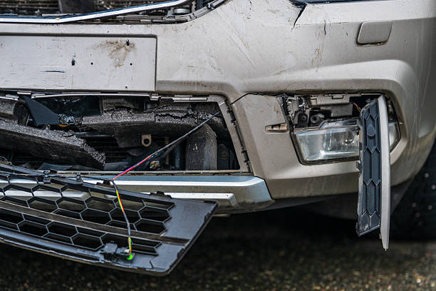 Close-up view of a car with a broken and detached rear bumper after a traffic accident, representing vehicle damage, insurance, and repair issues.