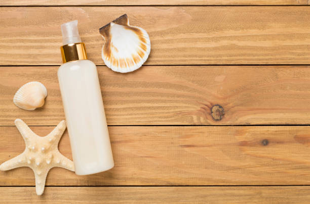 istock Sunscreen lotion with summer decor on wooden background, top view 2206274838