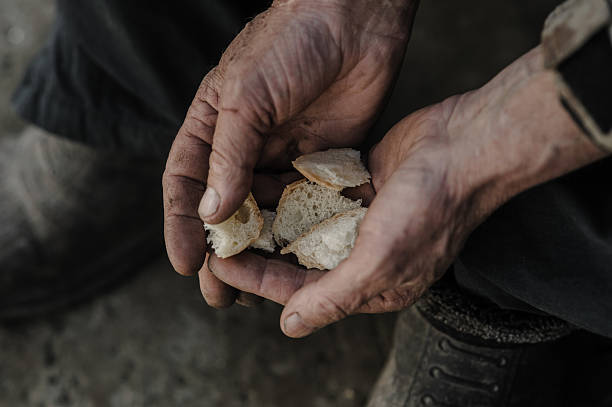 istock The trembling hands carefully hold the last bits of bread 2206276573
