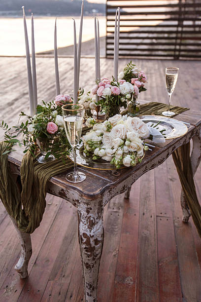 istock Rustic wedding table with floral decor and candles at sunset 2206278571