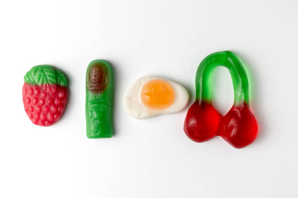 istock Gummy candies representing finger, strawberry, fried egg, and cherries on white background 2206279227
