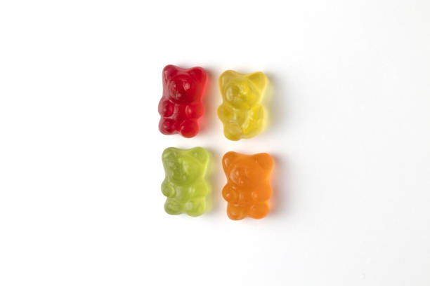 Four colorful gummy bears candy lying on a white background