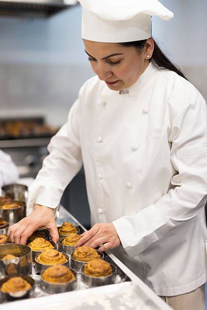 istock Female pastry chef organizing freshly baked mini cakes on the table 2206279604