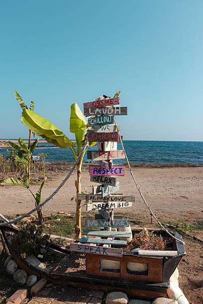 Directional post sign with inspirational sayings along the beach coast. Inspiration concept