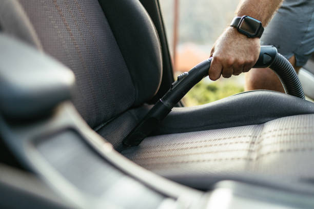 istock Man Vacuuming Car Seat Interior with Vacuum Cleaner in Sunlight 2206281208