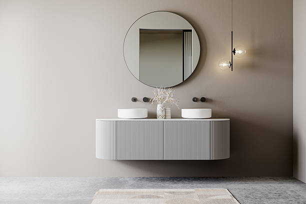 istock Modern bathroom interior with a floating vanity, round mirror, double vessel sinks, and minimalist lighting against a neutral wall. Elegant and contemporary design. 3D rendering. 2206281578