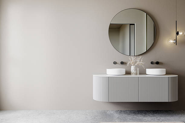 istock Modern bathroom interior with a floating vanity, round mirror, double vessel sinks, and minimalist lighting against a neutral wall. Elegant and contemporary design. 3D rendering. 2206281632