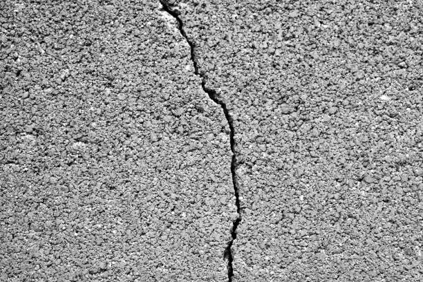 Dirty cracked cinder brick block concrete wall with gravel stones texture background. Old rough and grunge texture wall. Texture of cement wall.
