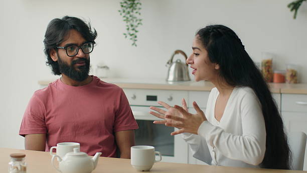istock Happy multiracial couple drink coffee tea in home kitchen friendly chatter Arabian man guy listen funny story carefree conversation Indian woman girl talk storytelling romantic date friends friendship 2206284457
