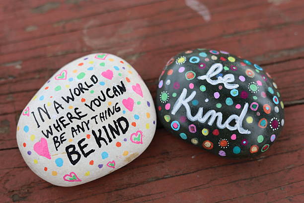 istock Two be kind kindness rocks on weather wooden picnic table surface 2206285684