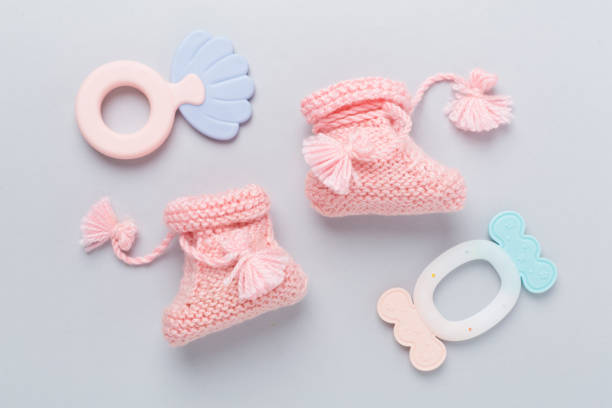 istock Pink baby booties and rattles on color background, top view 2206289030