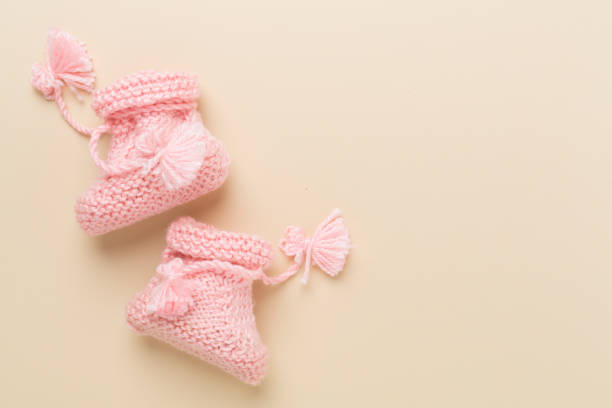istock Pink baby booties on color background, top view 2206289033