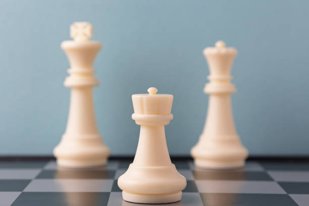 istock White queen standing in front of king and queen on chessboard 2206295796