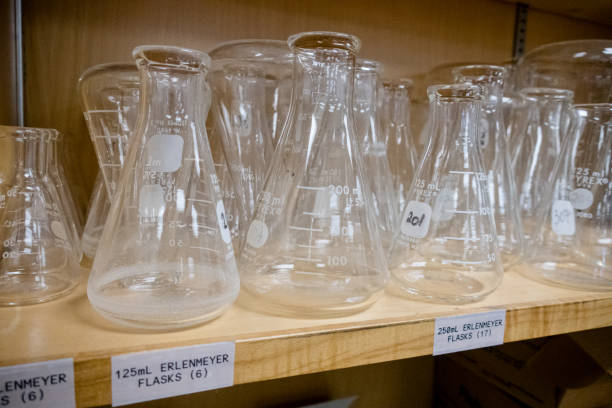 Close up of unrecognizable scientist taking laboratory flask with smoking purple liquid in laboratory.