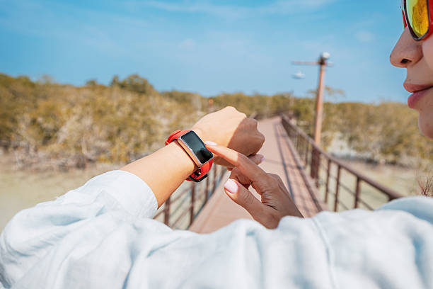 istock Person using a smartwatch on a bridge surrounded by nature, highlighting technology and outdoor exploration in a serene environment 2206304472