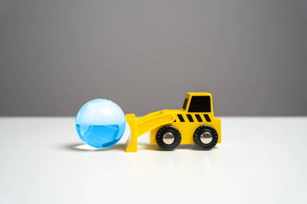 istock Bulldozer pushes planet earth blue globe. Human impact on the environment, prompting reflection on ecological concerns and the need for sustainable practices. 2206306176