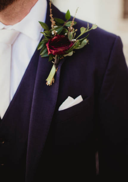 istock Groom with boutonniere pinned on suit jacket 2206313125