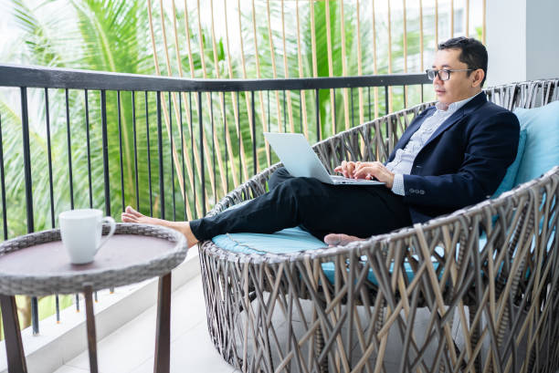 istock businessman using laptop on balcony hotel 2206323901