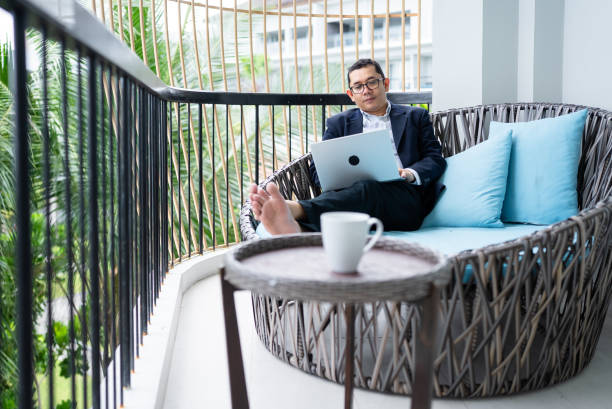 istock businessman using laptop on balcony hotel 2206323903