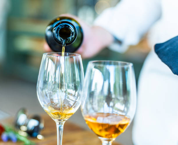 istock Pouring Amber Wine into Glass at Elegant Gathering 2206324457