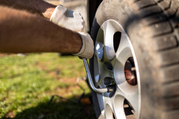Changing of tires on the car with tools close up. Seasonal work. Safety concept.