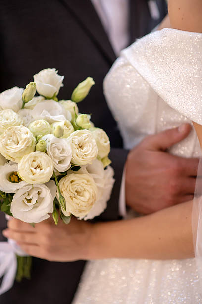 istock Bride in white dress with white flower bouquet 2206338081
