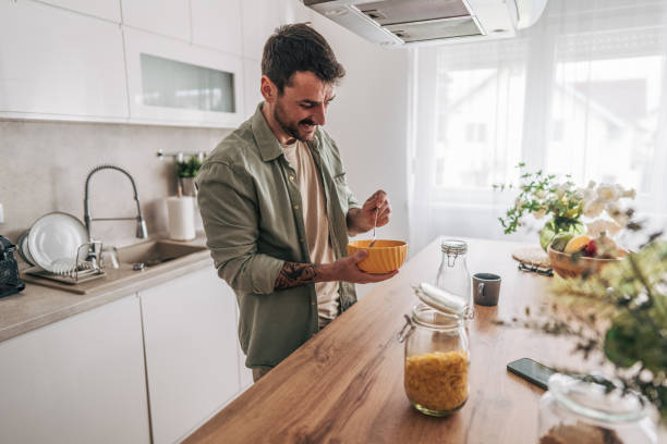istock Young man enjoying a healthy breakfast in modern kitchen 2206338901