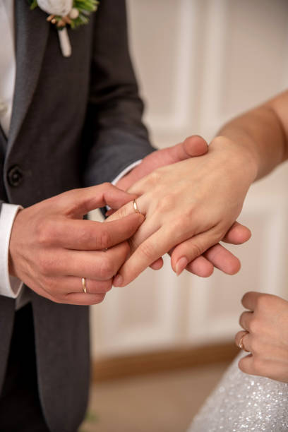 istock Groom puts a wedding ring on the bride's hand 2206339077
