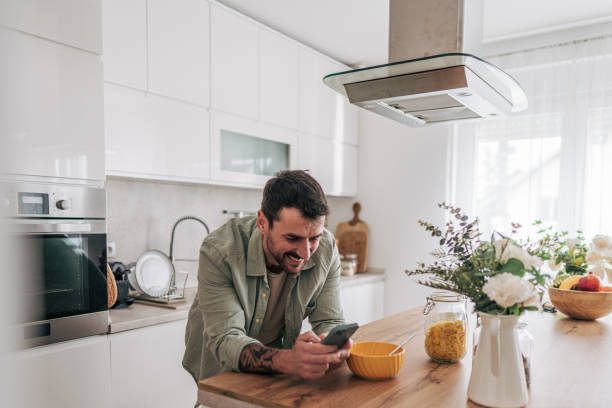 istock Young man enjoying breakfast and social media in modern kitchen 2206339139
