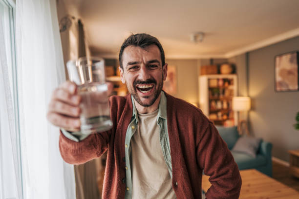 istock Happy man toasting with water glass at home 2206340307