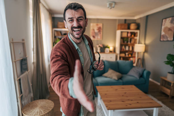 Smiling man shaking hand in living room at home