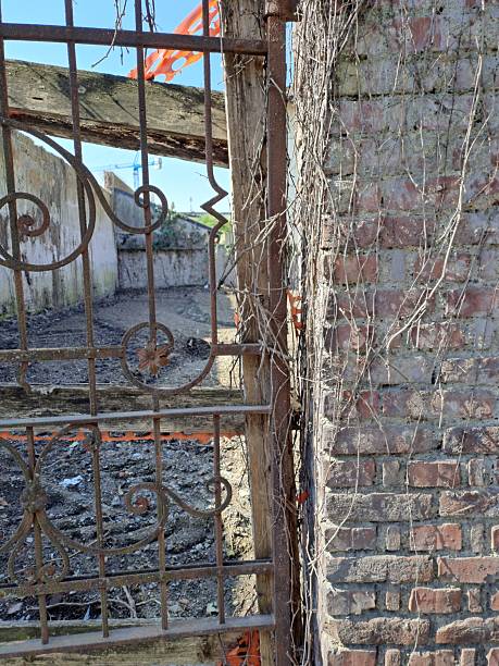 istock Brick wall supports rusty iron gate construction site in Italy 2206344535
