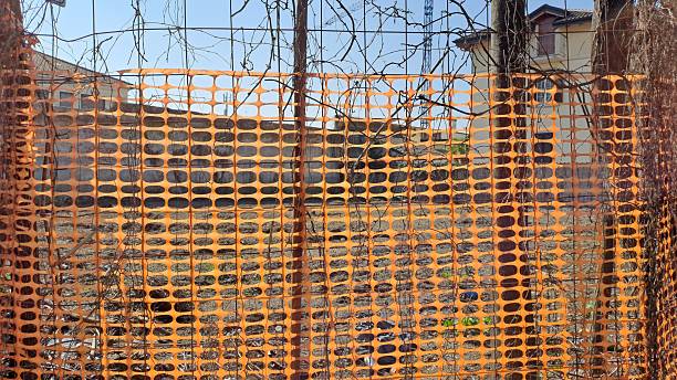 istock Rusty wire fence with plastic material  construction site in Italy 2206344544