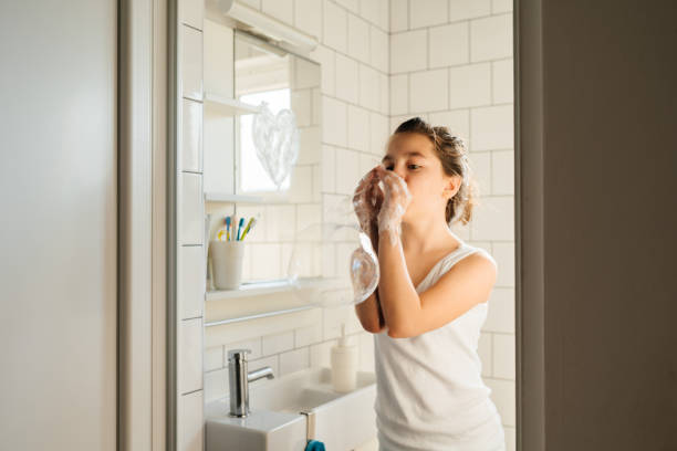 istock Young Girl Playing with Soap Bubbles While Washing Hands 2206347596