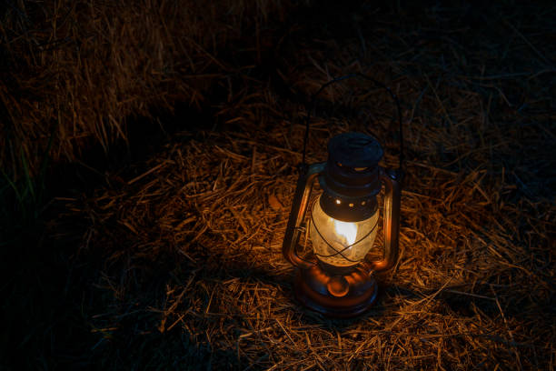 istock antique kerosene lamp with lights on a haystack in a barn at night 2206347702