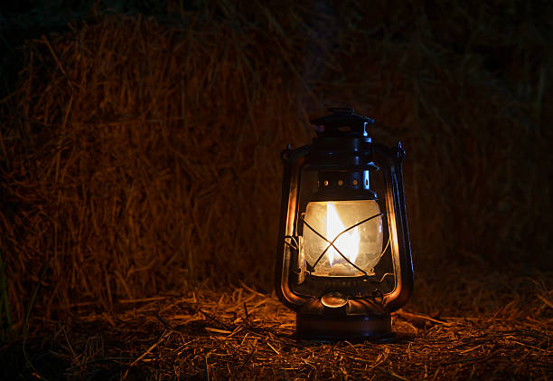 istock antique kerosene lamp with lights on a haystack in a barn at night 2206347703