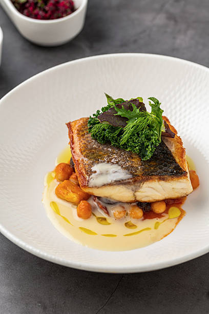 istock Crispy-skinned pan-seared fish fillet with chickpeas, creamy sauce, and fresh greens 2206348244