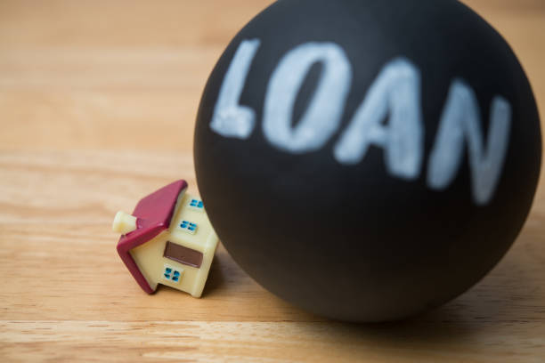 istock Heavy loan crash the house on wooden table background. 2206350912