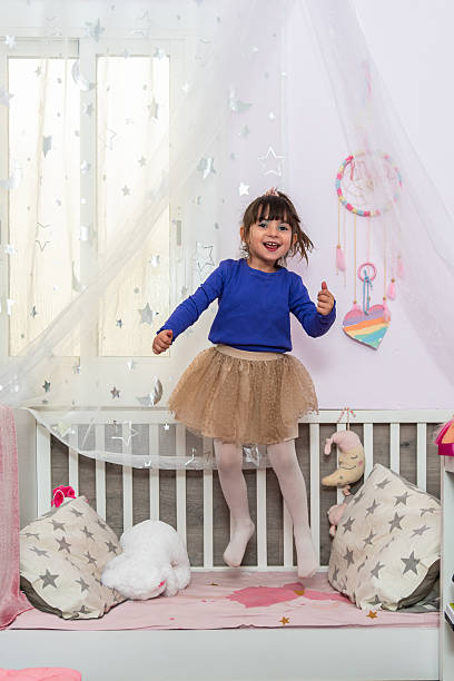 istock Happy child jumping on bed in decorated room 2206351647
