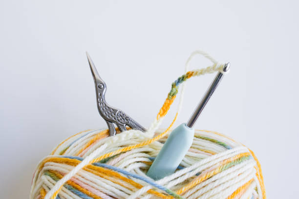 istock Colorful yarn ball with crochet hook and ornate scissors on white background 2206354476