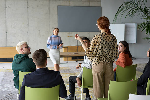 istock A diverse group of business professionals sits attentively in a modern office, actively participating in a training session led by an instructor, focusing on the latest technological advancements in the business world. 2206355347