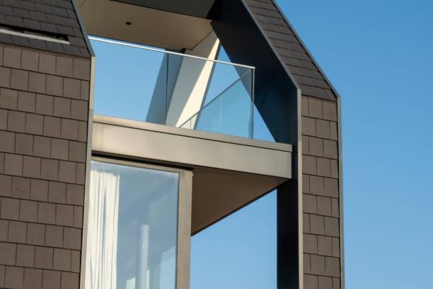 istock Modern house exterior showing balcony and tile cladding against blue sky 2206359132