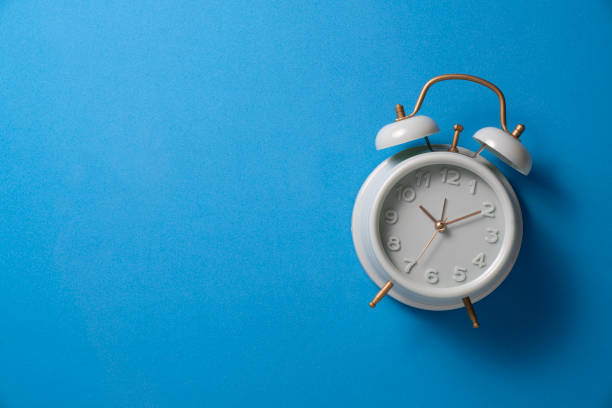 istock Retro alarm clock with blue background, vintage style. 2206359339