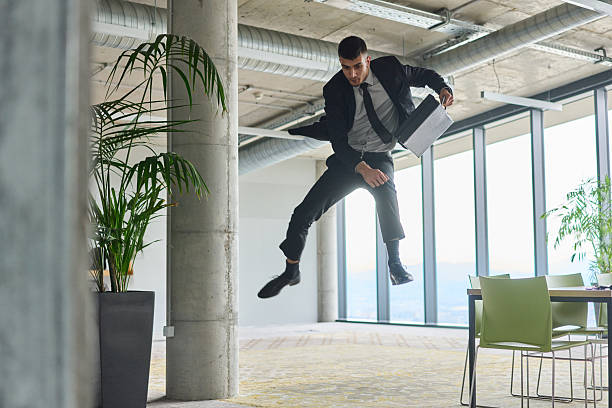 istock A businessman ecstatically jumping in a modern office, holding a briefcase in his hands, celebrating a moment of success and triumph. 2206361657